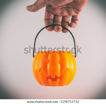 Isolated hand holding small halloween pumpkin on white background