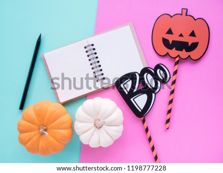 flat lay, halloween concept decoration with pumpkin and note book on pastel background, copy space.