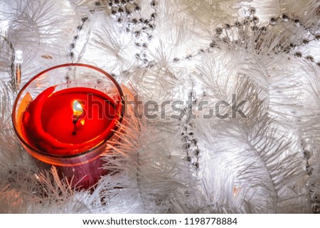 Christmas composition of white jewelry. Tinsel, cones, lanterns and candles. White Christmas snow. Shiny holiday decorations in warm soft light with wax candles. Picture of magic night