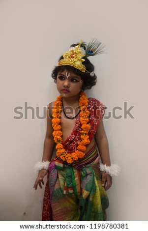 Cute Little girl child posing as an Indian God "KRISHNA" with natural poses