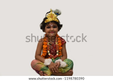 Cute Little girl child posing as an Indian God "KRISHNA" with natural poses