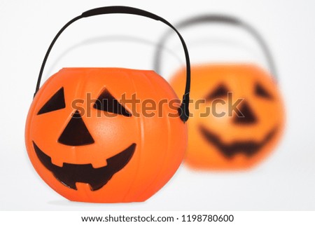 Jack O' Lantern Halloween pumpkin pail on white background. Orange plastic Trick Or Treat candy bucket made from resin with handle.