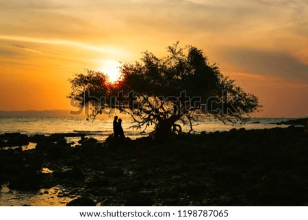 Silhouette of happy couple in love on the beach, Lovers having moments summer vacation for honeymoon.