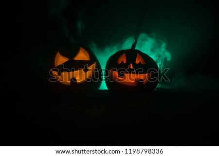 Group of Halloween Jack o Lanterns at night with a rustic dark foggy toned background. Selective focus