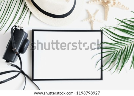 Summer composition. Photo frame, camera, tropical palm leaf branches, hat on white background.Travel vacation concept. Summer background. Flat lay, top view, copy space