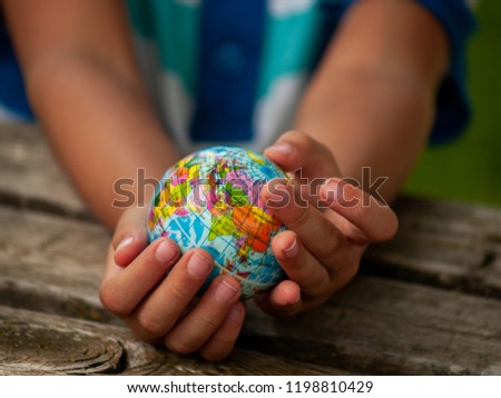 A boy with a ball of the world or planet Earth in his hands. Ecology concept Royalty-Free Stock Photo #1198810429
