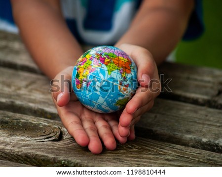 A boy with a ball of the world or planet Earth in his hands. Ecology concept Royalty-Free Stock Photo #1198810444