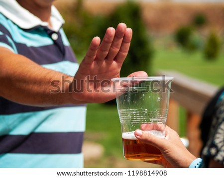 Stop alcohol concept. A man making a stop gesture to a glass of beer Royalty-Free Stock Photo #1198814908