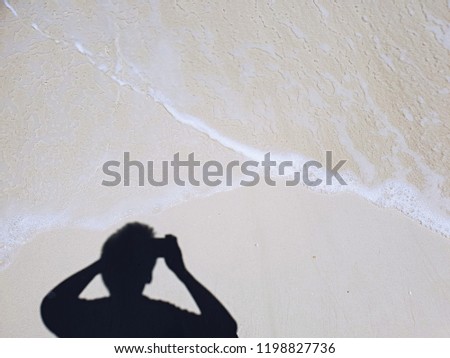 People shadow take a picture of soft beautiful ocean wave on sandy beach background,selective focus
