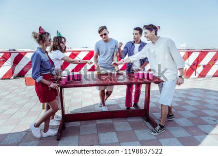 Group game. Handsome boy standing in semi position while talking to his partners