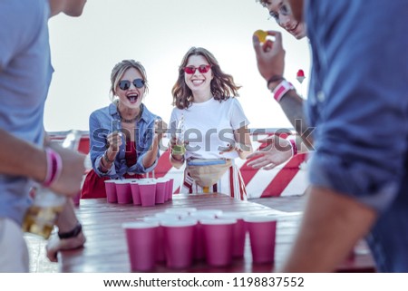 Hurray. Cheerful brunette keeping smile on her face while enjoying friendly atmosphere