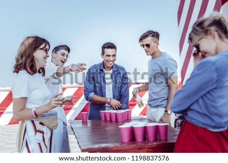 Lets prepare. Pleased international man keeping smile on his face while playing table game