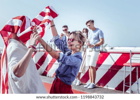 Lets dance. Charming female standing in semi position while holding American flag