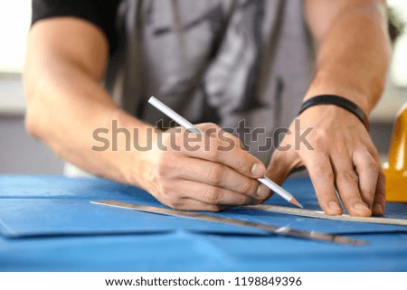Male hand holding pencil in hand. Engineering blueprint design for buildings of blue architecture tools to achieve a human activity