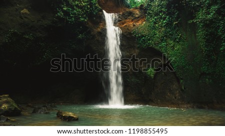 
Close-up of stunning waterfall Tibumana Waterfall, Bali, Indonesia. Tourist enjoy and relax on Bali, a stunning island