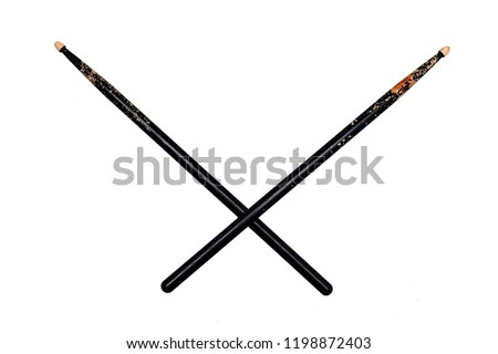 two crossed used black drumsticks on white background