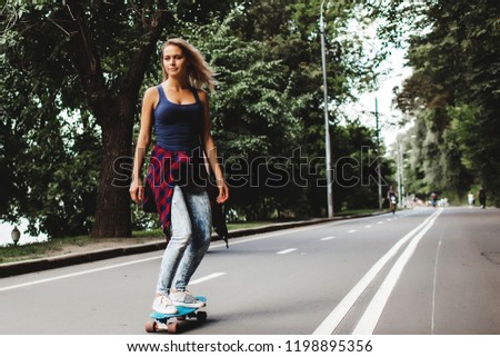girl posing with skate board in city park