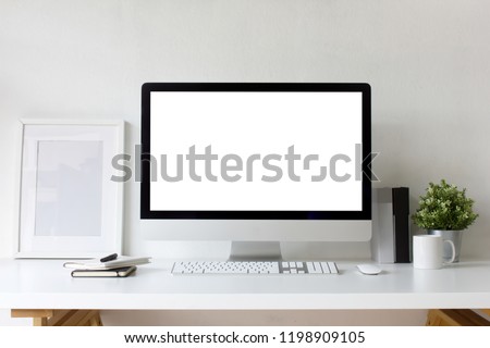 Front view office table desk. Workspace with blank computer screen, keyboard, mouse, booklets, pen, white picture frame , plant mockup, cup, books and white background