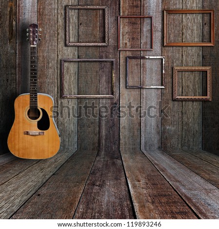 Guitar and picture frame in vintage wood room.