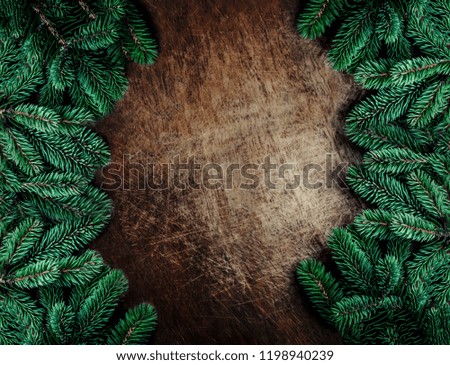Christmas frame made of  fir branches on  dark rustic wooden background. Christmas wallpaper. Flat lay, Copy space