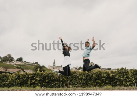 
Young couple in love, touring the vineyards of France at the time of grape harvest. Having fun taking pictures while jumping. Lifestyle