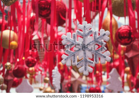 Christmas snowflakes in fair kiosk with red handcrafted xmas decorations. Close up.
