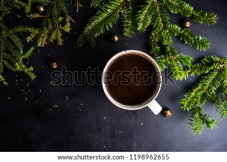 Cup of coffee on dark wooden background with holiday decor and copy space