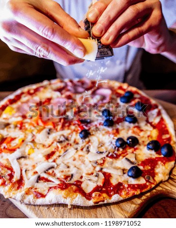 Pizza with cheese, peppers and olives on the board