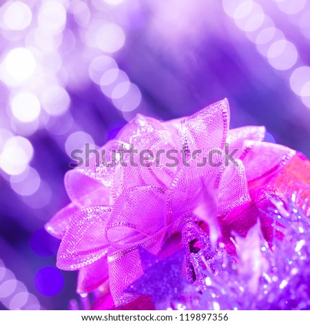 Picture of pink ribbon bow on purple glowing background, Christmas present, New Year gift, holiday decorations, festive ornament, birthday party, Valentines day, celebration concept