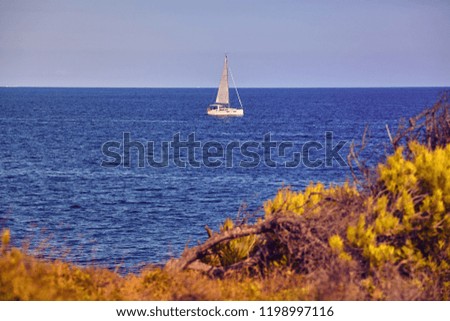 Lonely sailboat on Mallorca coast, color toned picture, Spain.