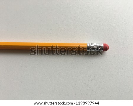 Yellow number 2 pencil two eraser sharpen dull white background close up object desk table writing test testing
