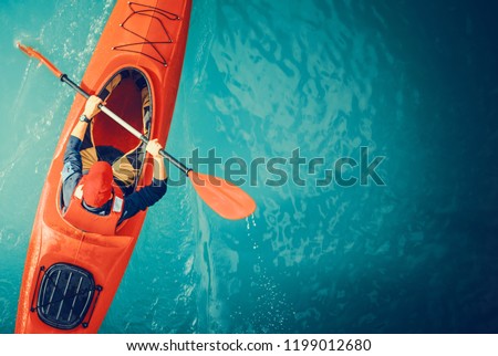 Kayaker Lake Tour Aerial Photo. Red Kayak and Caucasian Paddling Sportsman in His 30s. Royalty-Free Stock Photo #1199012680