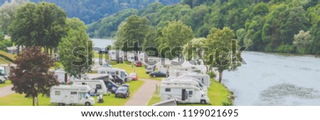 Blurred banner background with Modern camp site on  river Neckar, Germany. Traveling Europe in motorhome. Family vacation in caravan park. Caravan camping on the summer beach