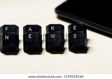 Word "Fake News" sticks with computer keyboard keys. Mobile background device. Concept photo.