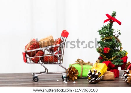 Closeup shopping cart and beautiful composition frame of Christmas decorations with golden ball, pine cone, star, present or gifts, ribbons on white background with copy space/ Christmas concept