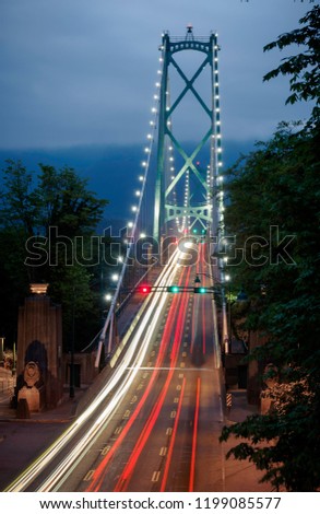 Cars speed across the bridge at night.