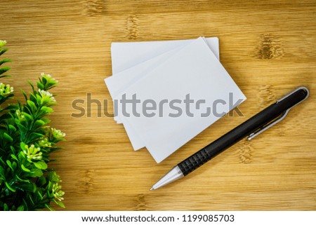 stacking of mockup empty white business card with elegance pen  on wooden background , template for business  branding identity design