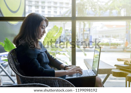 Beautiful young asian woman using computer notebook with her business online shopping in a coffee shop and restaurant