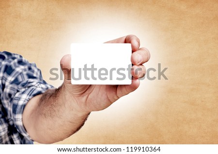 Man holding the blank white card on the orange background