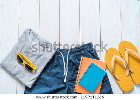 men's casual outfits of traveler, summer holiday on wood background