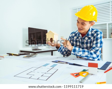 Asian man architect construction startup working on project housing blueprint.