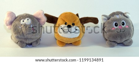 Small soft children's toys depicting elephant cubs, dogs and cats. The picture was taken in close-up on a white background.
