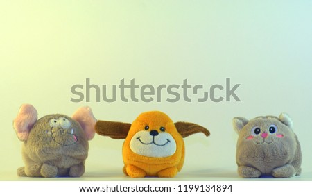 Small soft children's toys depicting elephant cubs, dogs and cats. The picture was taken in close-up on a white background.
