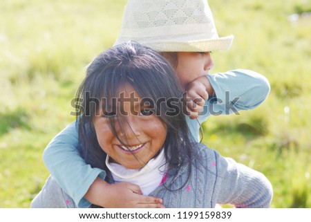 Native american girl holding her little sister in the countryside. Royalty-Free Stock Photo #1199159839