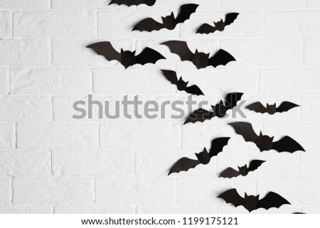 Paper bats on brick wall with space for text. Halloween decor
