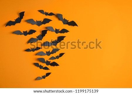 Paper bats on color background with space for text. Halloween decor