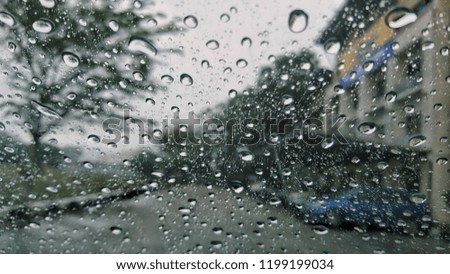 Raindrops falling on glass, abstract blurs. 
