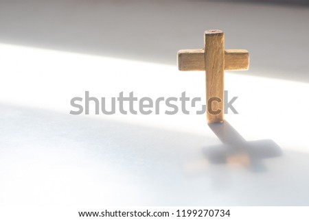 Wooden Christian cross on white floor. Christianity Concept. Faith hope love concept.