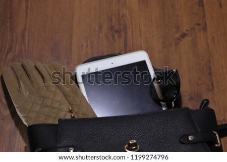 Cute bag for women, sunglasses, gloves with fur and Tablet computer on the table