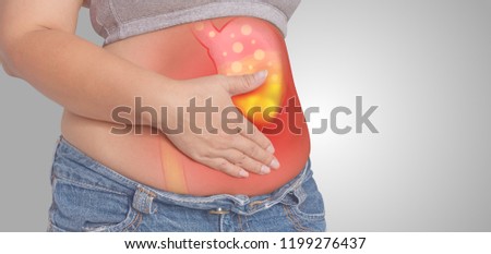 Acid reflux or Heartburn, stomach is on the woman's body gray Background, anatomy concept  Royalty-Free Stock Photo #1199276437